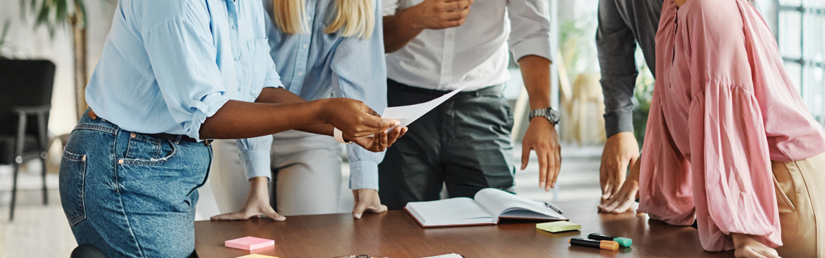 group of corporate workers standing around desk
