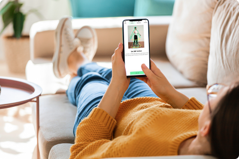 person lying on sofa with scan app on mobile phone